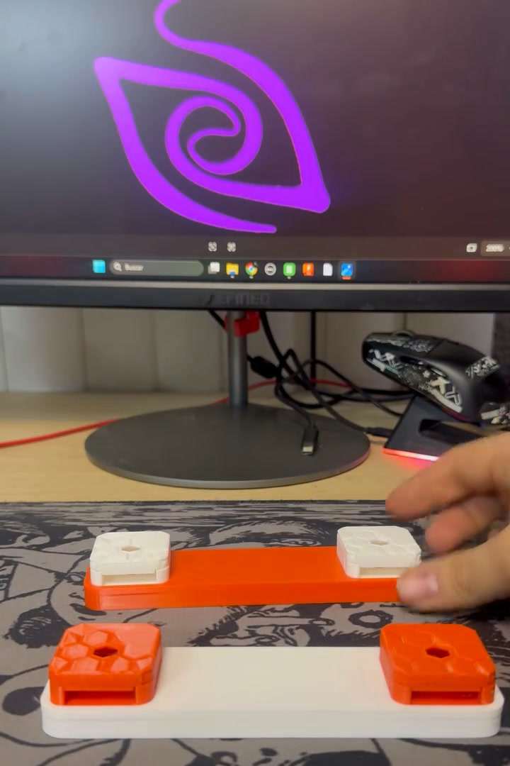 Soportes naranja y blanco para cámaras Raspberry Pi, frente al logo de PROIN en un monitor